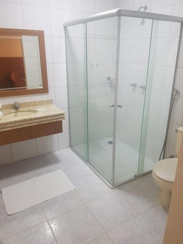 a bathroom with a shower and a sink and a toilet at Collina Hotel in Camapuã