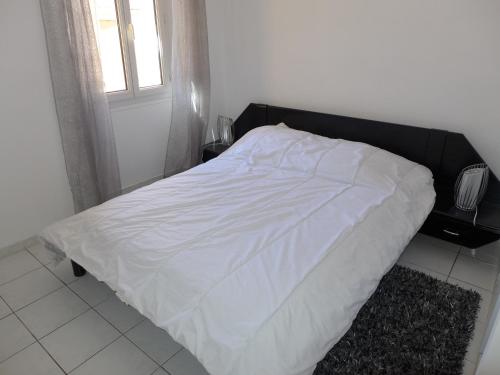 ein weißes Bett mit einem schwarzen Kopfteil in einem Schlafzimmer in der Unterkunft Central 1 bedroom Riouffe 2 mins from the Palais and Croisette 206 in Cannes
