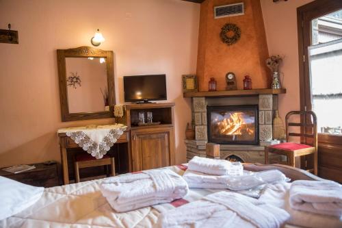 a bedroom with a bed and a fireplace and a mirror at Archontiko Tsiboni in Elati