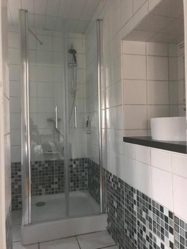une douche avec une porte vitrée dans une salle de bain dans l'établissement Appartement Rez de villa - Porte des Calanques, à La Redonne