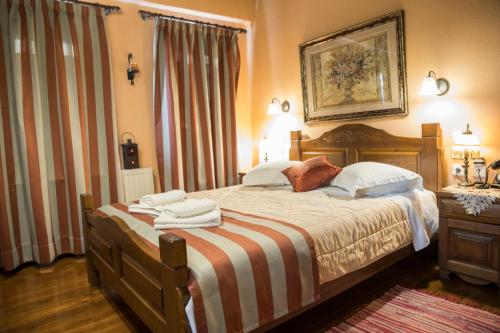 a bedroom with a large bed with towels on it at Archontiko Tsiboni in Elati Trikalon