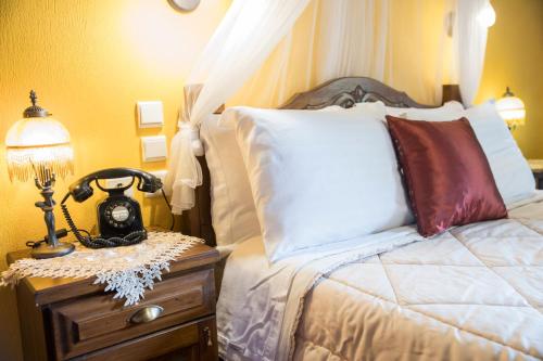 a bed with a lamp on a nightstand next to it at Archontiko Tsiboni in Elati Trikalon
