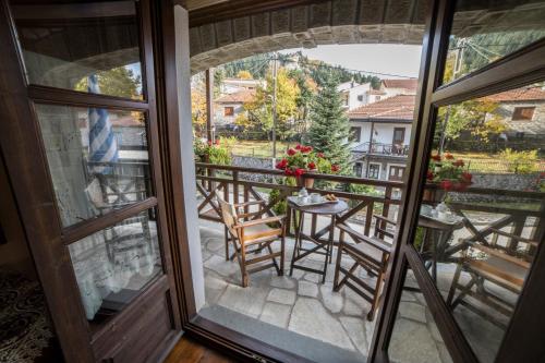 a balcony with chairs and a table with a view at Archontiko Tsiboni in Elati Trikalon