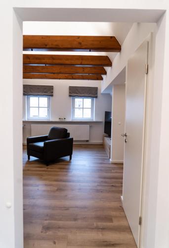 a living room with a black couch and wooden ceilings at AMBERG [APART] - Wohnung [CITY] - Wohnraum auf Zeit in Amberg