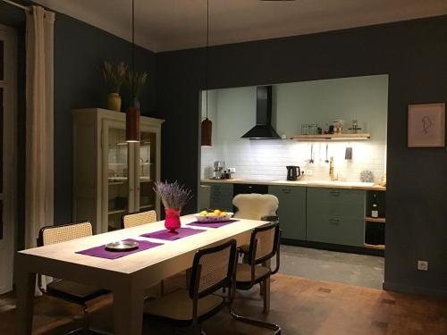 une cuisine avec une table et des chaises dans une pièce dans l'établissement Modern, traditional , bright and stylish appartement, à Nice