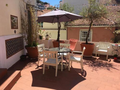 a patio table with chairs and umbrellas at Costa do Castelo Terrace in Lisbon