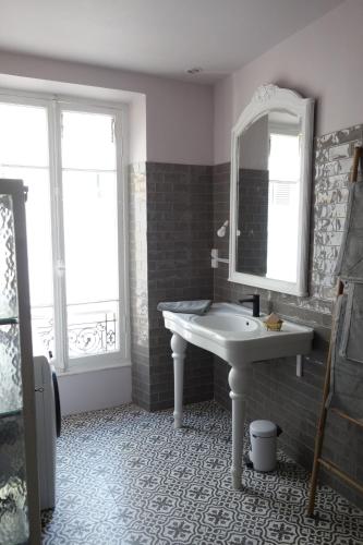 une salle de bain avec un lavabo et un miroir dans l'établissement Modern, traditional , bright and stylish appartement, à Nice