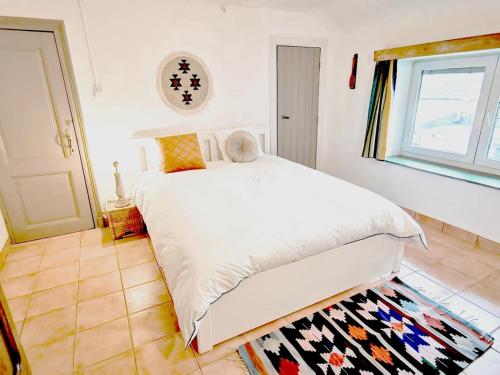 ein Schlafzimmer mit einem weißen Bett und einem Fenster in der Unterkunft Studio la Gileppe in Jalhay