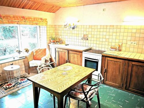 eine Küche mit einem Tisch, einem Tisch und Stühlen in der Unterkunft Studio la Gileppe in Jalhay