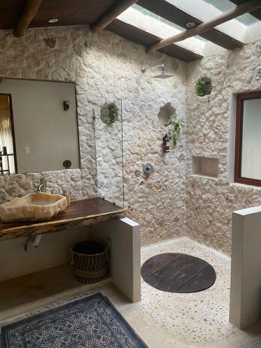 a stone bathroom with a sink and a shower at Xoot Ka’Ana Villa Corazón in Bacalar