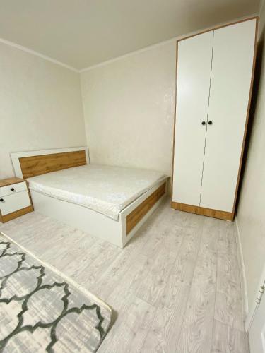 Dormitorio pequeño con cama y armario en Апартаменты на Ахметова 6, en Turksib