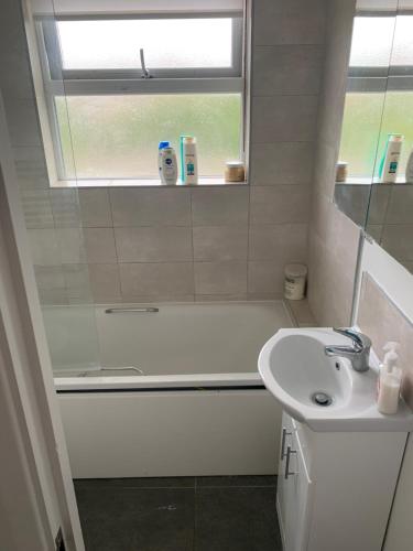 a bathroom with a tub and a sink and a shower at Immaculate 4 bedroom house Near central London in Edgware