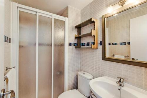 a bathroom with a toilet and a sink and a mirror at Remarkable 3-Bed Apartment in Chipiona in Chipiona