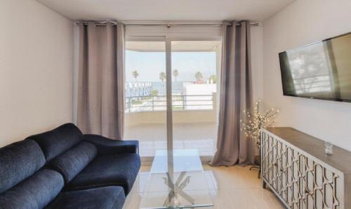 a living room with a couch and a large window at Remarkable 3-Bed Apartment in Chipiona in Chipiona