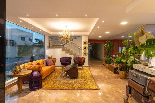 a living room with a couch and a chandelier at VILLA NOMAD HOTEL in Uberaba