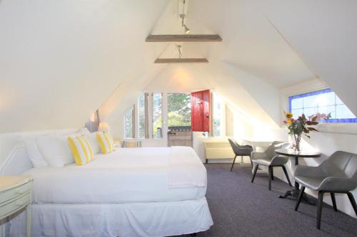 1 dormitorio con cama blanca y mesa con sillas en Forest Lodge, en Carmel