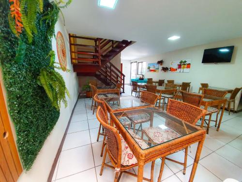 um restaurante com mesas e cadeiras e uma escadaria em Pousada Quaraçá Maceió Pajuçara em Maceió