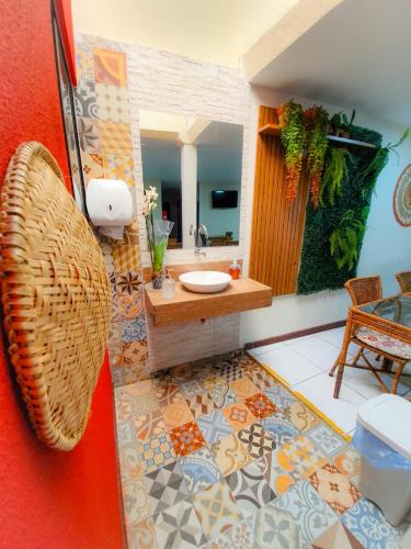 a bathroom with a sink and a mirror at Pousada Quaraçá Maceio in Maceió