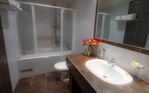 a bathroom with a white sink and a toilet at Pantelidis Hotel & Spa in Ptolemaida