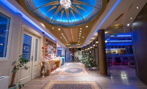 a store hallway with a blue ceiling and a christmas tree at Pantelidis Hotel & Spa in Ptolemaida