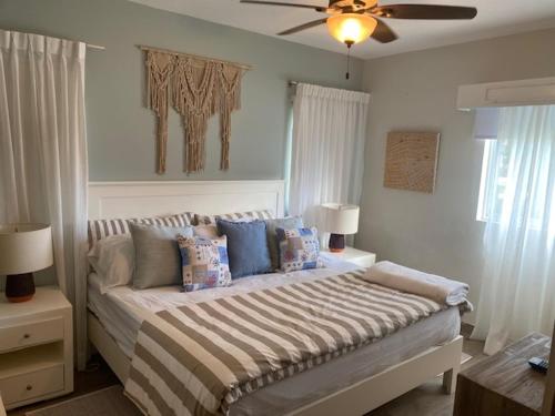 a bedroom with a bed with pillows and a ceiling fan at Cadaques Caribe Bayahibe in Bayahibe