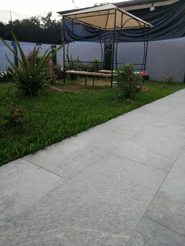 a picnic table and a bench in the grass at Habitaciones del Pacifico in Zihuatanejo
