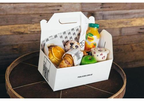 een witte doos met eten en drinken op een tafel bij Avgerinos Deluxe Rooms in Paliochori