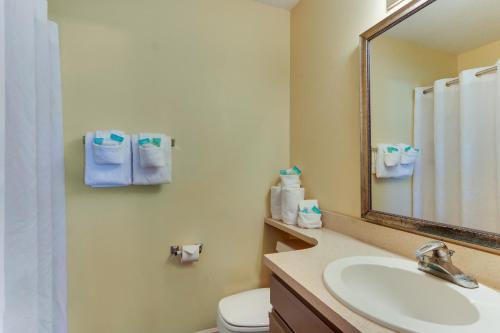 uma casa de banho com um lavatório, um WC e um espelho. em Mariners Suites - Kingsland em Kingsland