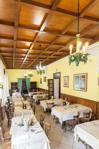 a restaurant with white tables and chairs and wooden ceilings at Hotel Ristorante San Carlo in Salsomaggiore Terme