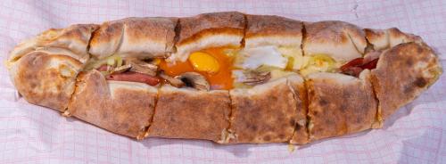 a large sandwich with an egg on a table at Pantelidis Hotel & Spa in Ptolemaida