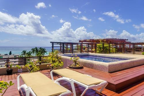 un patio con piscina, 2 sillas y el océano en Aldea Thai by Stella Rentals, en Playa del Carmen