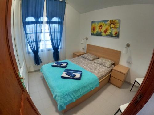 sypialnia z łóżkiem z niebieskimi ręcznikami w obiekcie HATO Holiday Home Fuerteventura w mieście Costa Calma