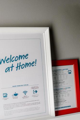 a picture frame with a welcome at home sign at Anjoy&Bleev Rooms in Rho