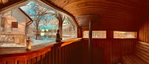 een kamer met een groot raam in een houten huis bij Romantic Spa Villa with Fireplace by the lake in Stjärnsund