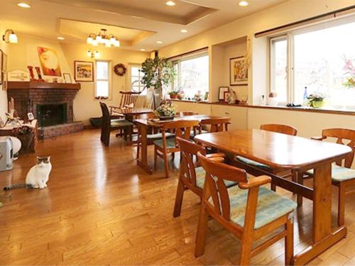 uma sala de jantar com mesas e um gato sentado no chão em Blanche Mori - Vacation STAY 86835v em Hokuto