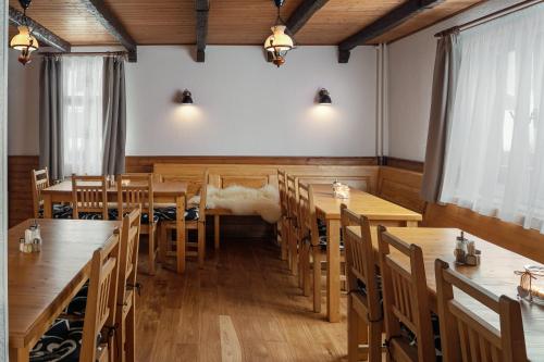a dining room with wooden tables and chairs at U Komárků in Špindlerův Mlýn