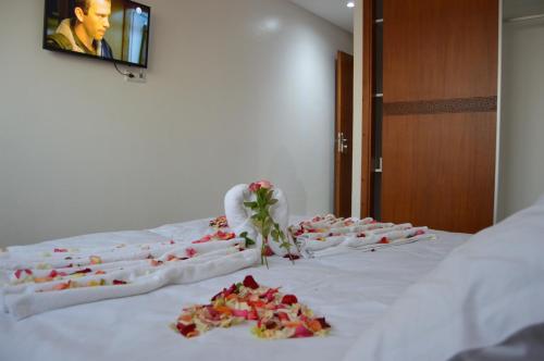 a group of roses on a bed in a room at Hôtel Zahrat Souss -Inezgane in Inezgane