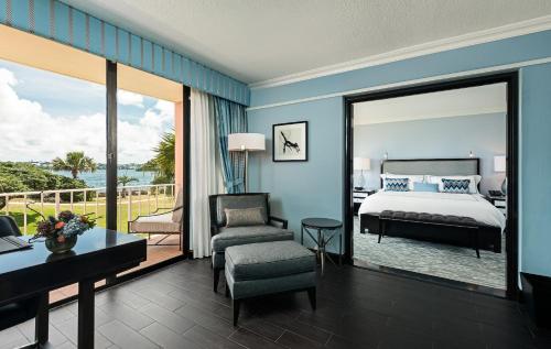 a bedroom with a bed and a living room with a balcony at Hamilton Princess & Beach Club A Fairmont Managed Hotel in Hamilton