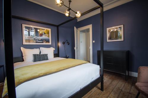 a bedroom with a canopy bed with blue walls at Gite Villa Avril piscine- jacuzzi- sauna - 15 Pers-proche Europapark in Sélestat