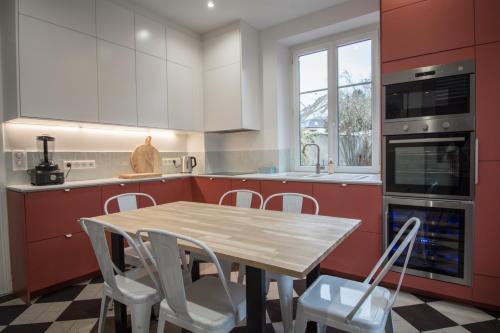 a kitchen with a wooden table and white cabinets at Gite Villa Avril piscine- jacuzzi- sauna - 15 Pers-proche Europapark in Sélestat