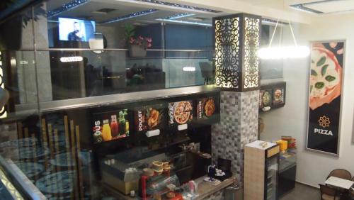a restaurant with a display of food and a tv at Hôtel Zahrat Souss -Inezgane in Inezgane