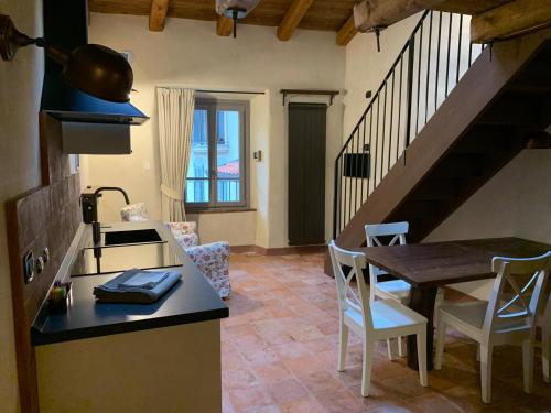 a kitchen and dining room with a table and a counter top at Foresteria Antica Farmacia in Cedegolo