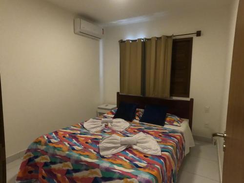 a bedroom with a bed with a bow on it at Apartamento em Barra do Cunhaú in Barra do Cunhau