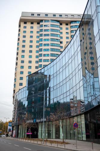 a large building with glass windows on a street at Luxury Apartment Karic FREE parking in Tuzla