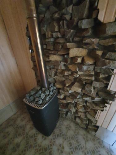 a stone wall with a trash can next to a fireplace at Stanica Karpacka 4x4 in Mohnate