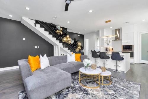 a living room with a couch and a staircase at The Suite Spot! Downtown Skyline Views! Sleeps 12 in Houston