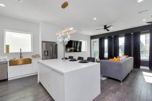 a kitchen and living room with a white island and a couch at The Suite Spot! Downtown Skyline Views! Sleeps 12 in Houston