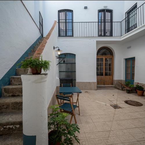 a patio with stairs and a blue table in front of a building at Apartamentos Petronila 1881 in Mérida