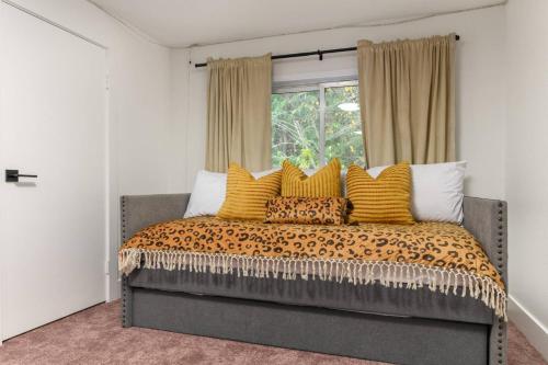 a bedroom with a bed with yellow pillows and a window at Tanner Basin Retreat in West Linn