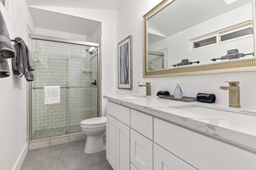 a white bathroom with a toilet and a mirror at Tanner Basin Retreat in West Linn